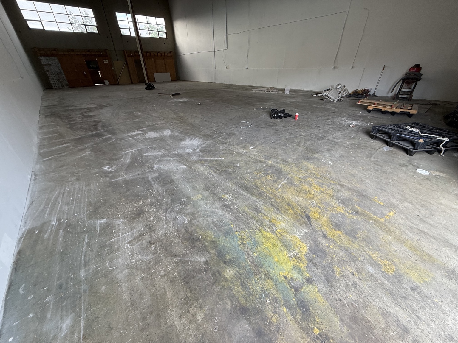 Worn concrete floor with old surface markings before grinding.