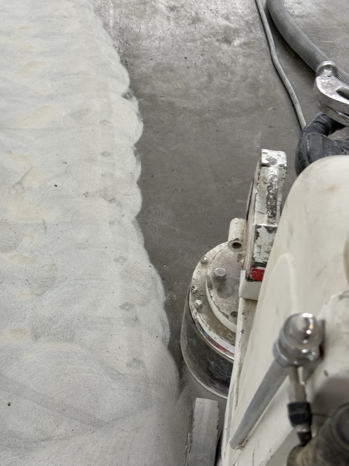Floor grinder removing the old concrete surface beside a freshly ground section.