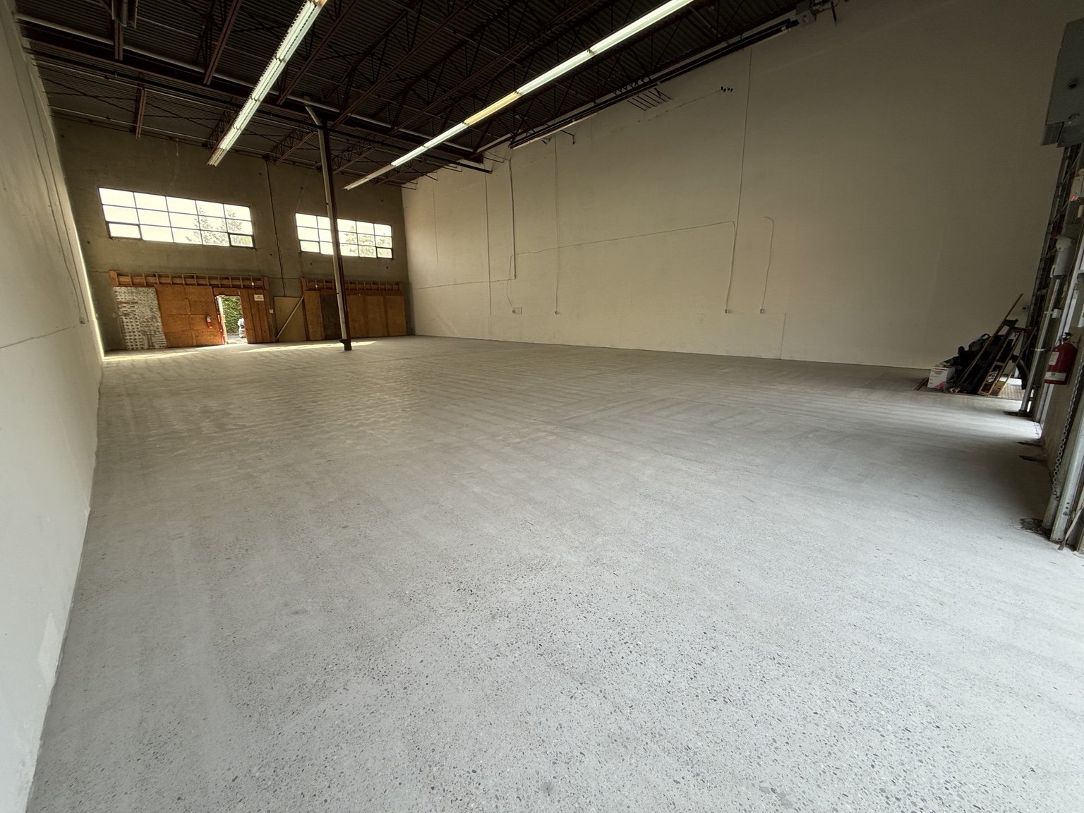 Wide view of the exposed concrete floor after mechanical grinding.